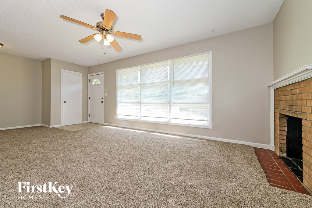 A room with a fireplace and a ceiling fan.
