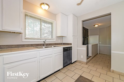A kitchen with white cabinets and a sink.
