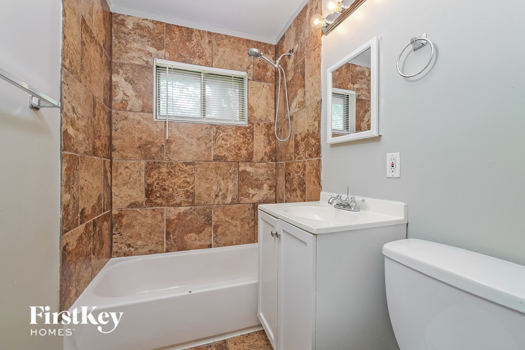 A bathroom with a tub, sink, and shower.