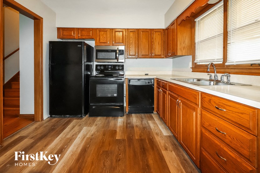 a kitchen with black appliances and wooden cabinets