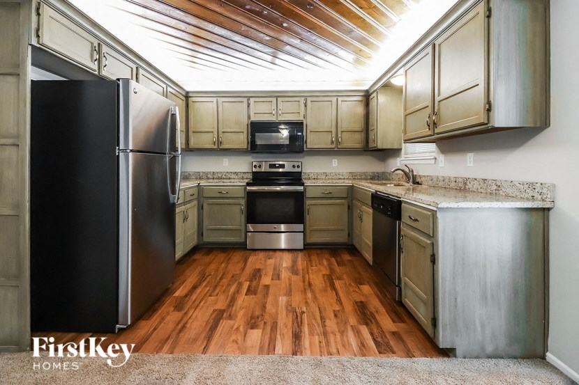 a kitchen with wooden floors and stainless steel appliances