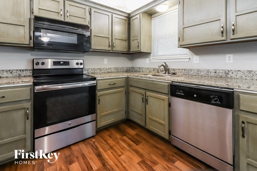 a kitchen with stainless steel appliances and wooden floors