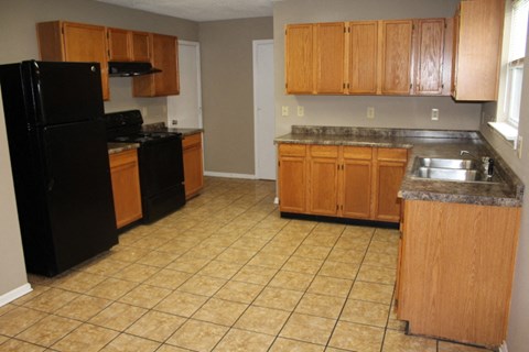 A kitchen with black appliances and wooden cabinets.