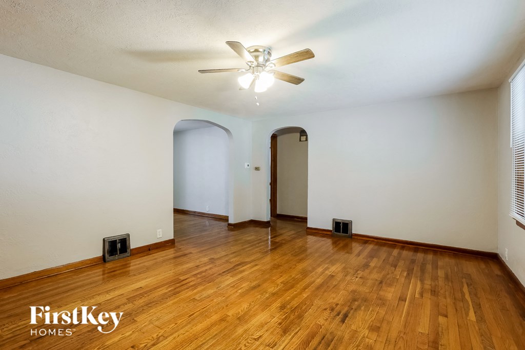 the living room with hardwood floors and a ceiling fan