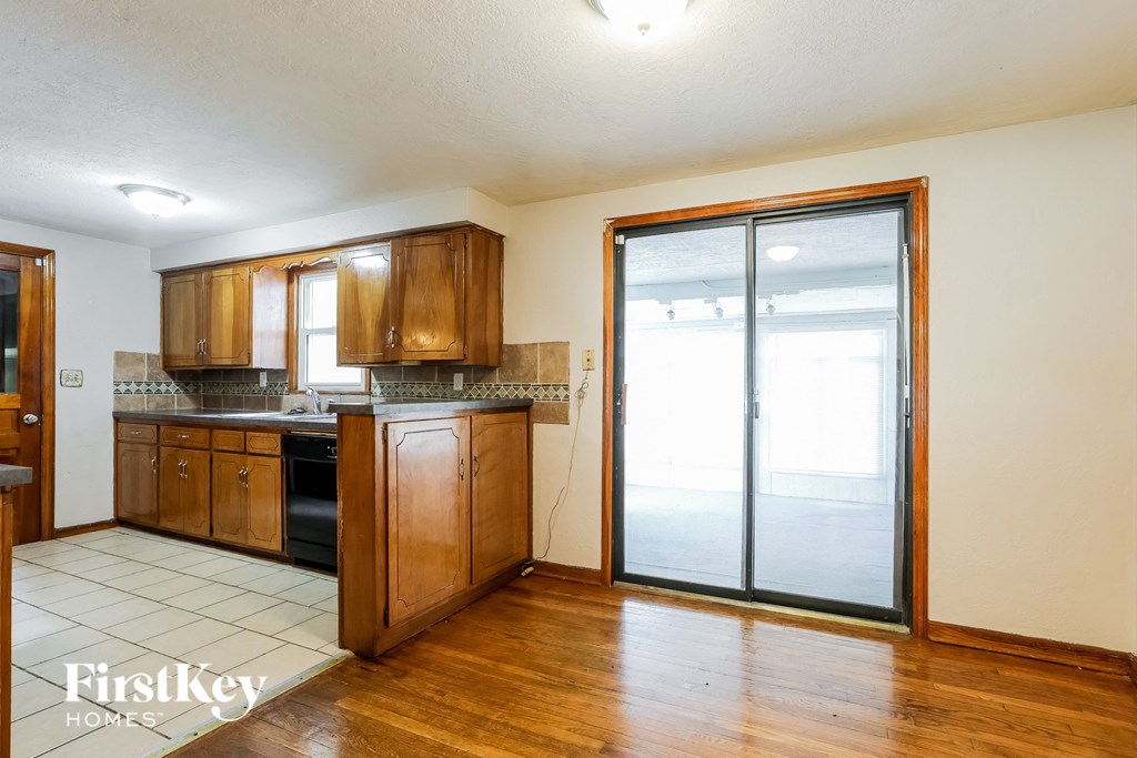 a kitchen with wooden cabinets and a sliding glass door