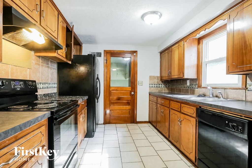a kitchen with black appliances and wooden cabinets