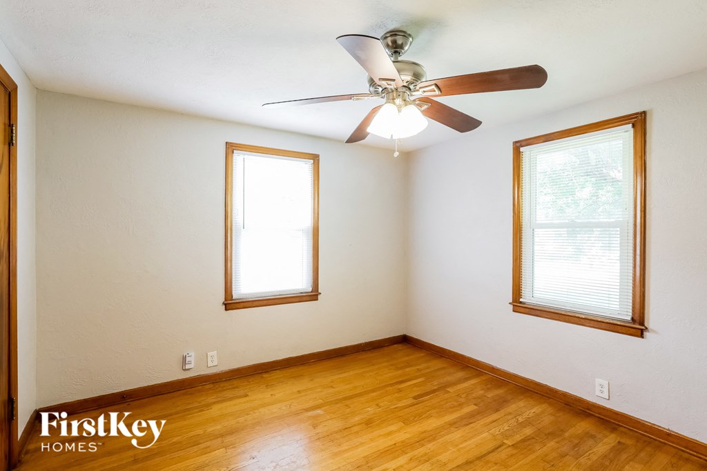 a living room with wood floors and a ceiling fan