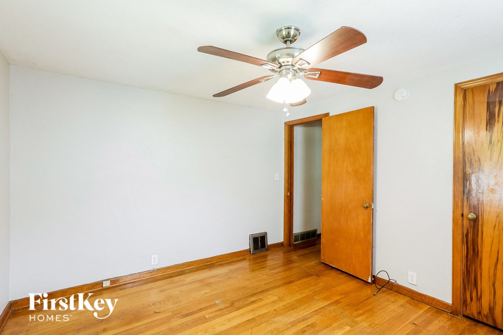 the living room of a house with wood floors and a ceiling fan
