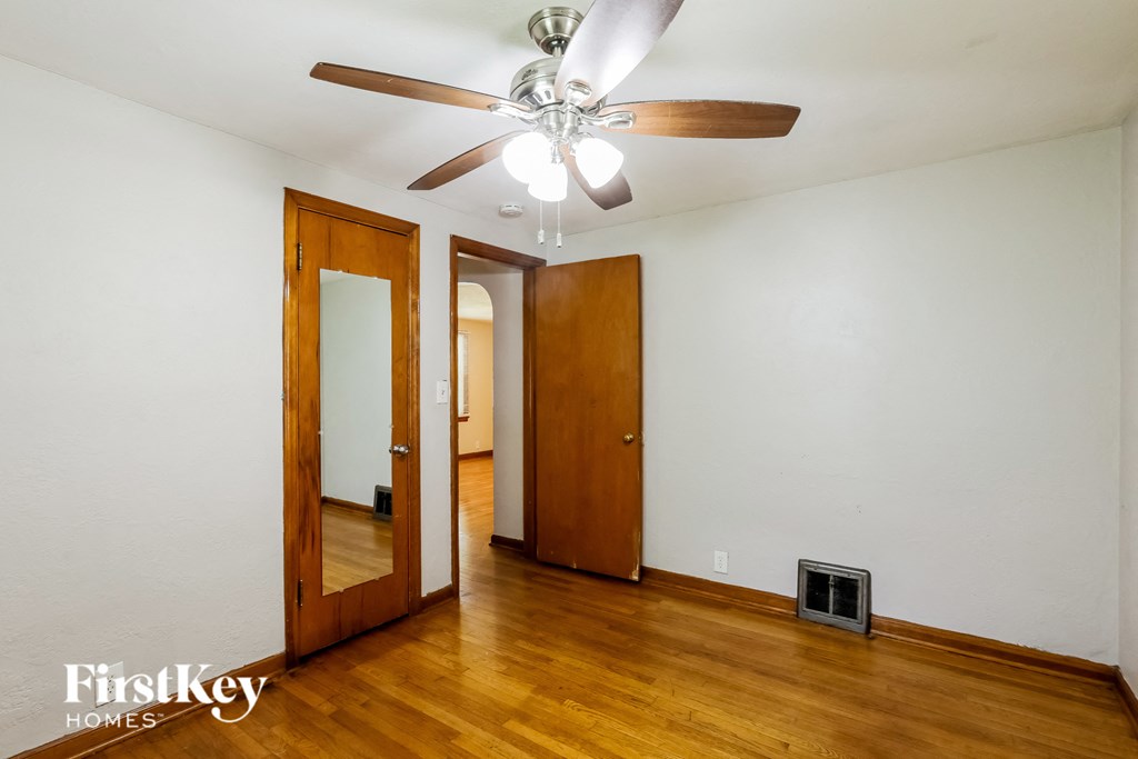a living room with wood floors and a ceiling fan