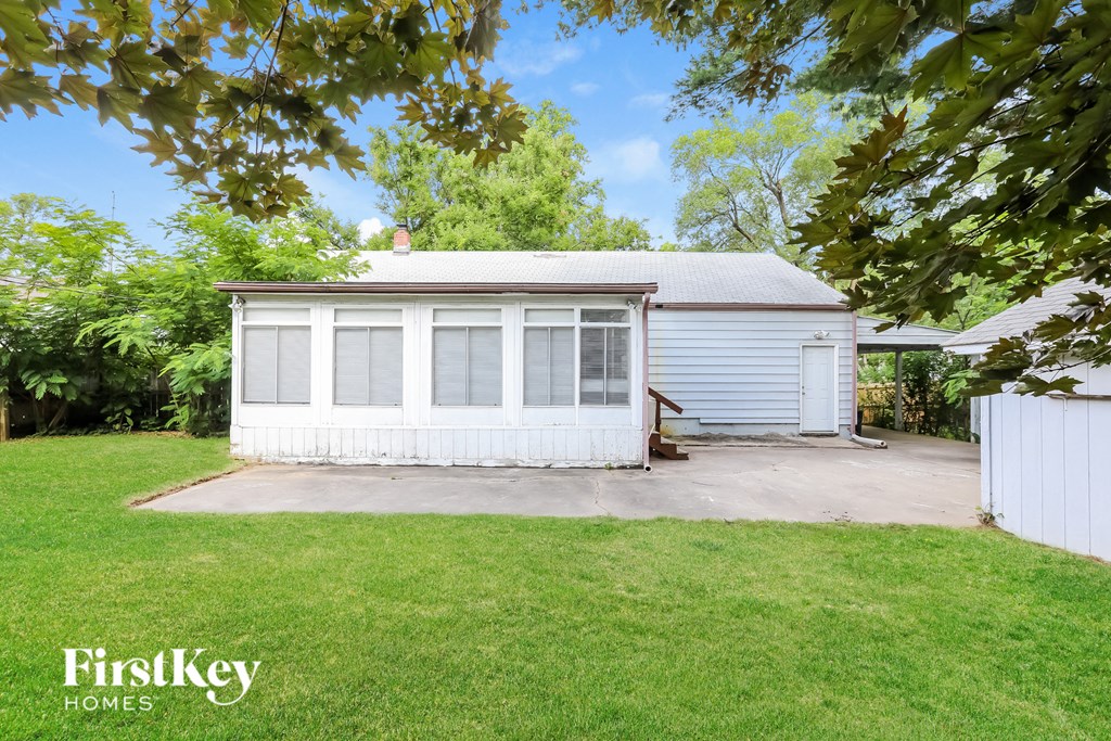 a small white house with a driveway and a lawn