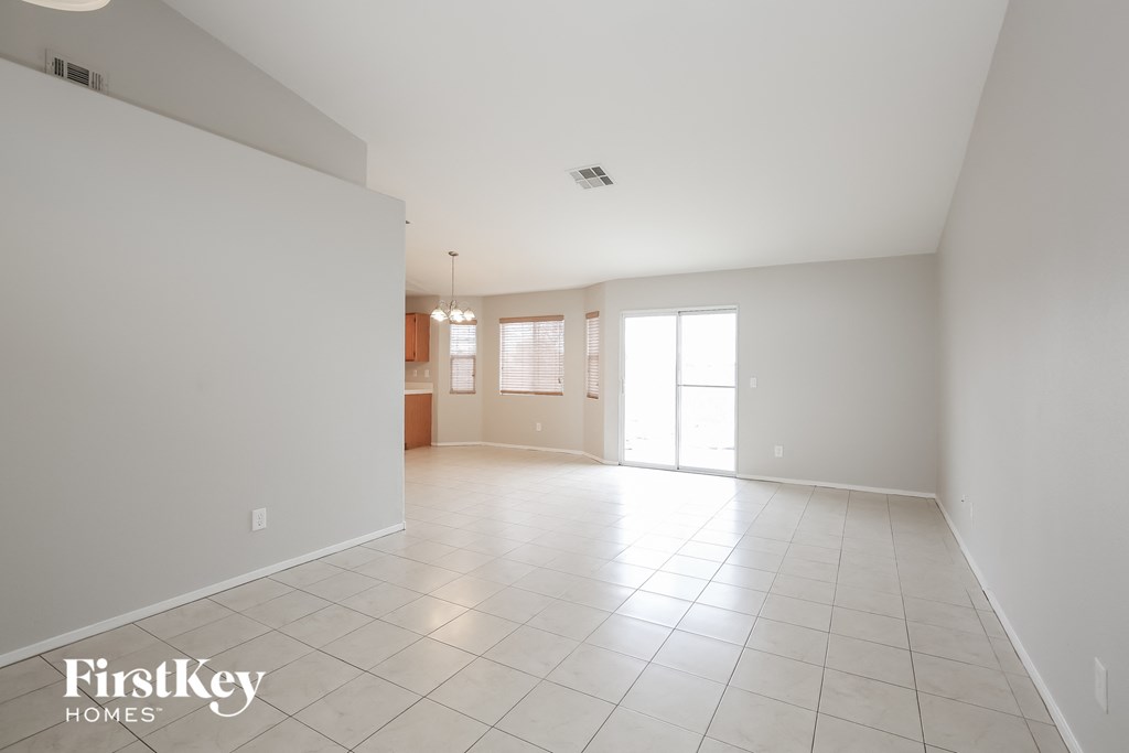 A spacious, empty room with a tile floor and a large window.