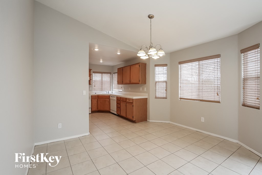 A spacious kitchen with white tiled floors and wooden cabinets.