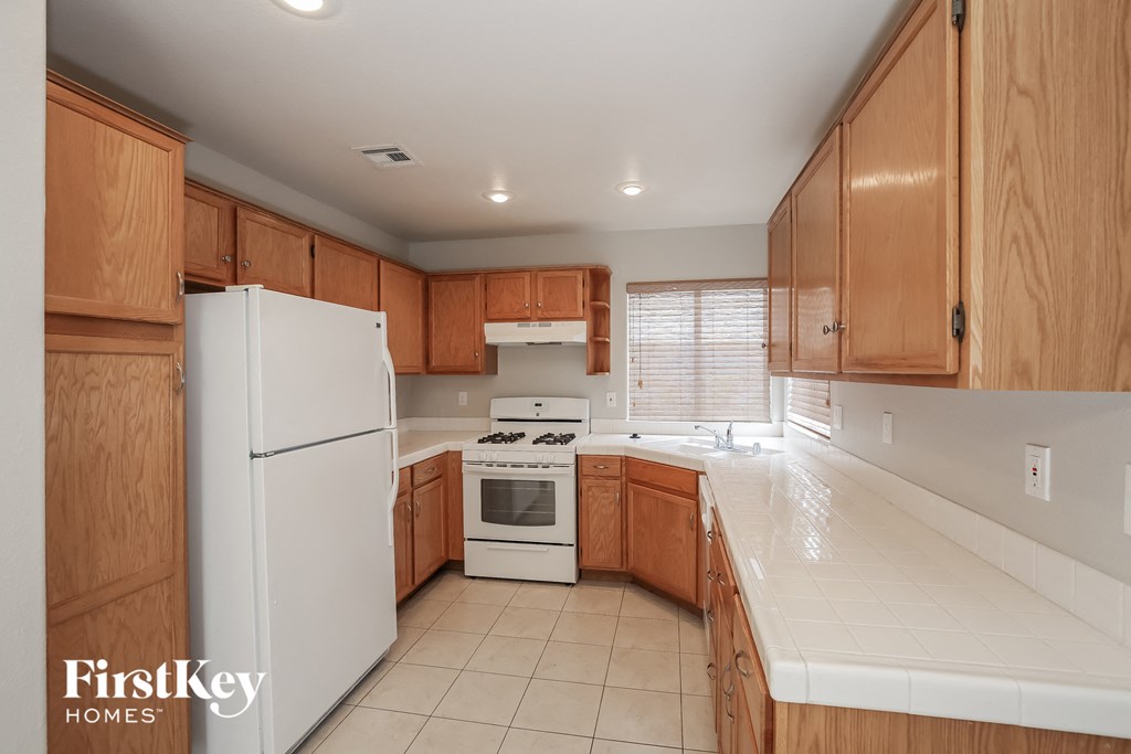 A kitchen with wooden cabinets and a white refrigerator.
