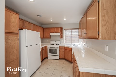 A kitchen with wooden cabinets and a white refrigerator.