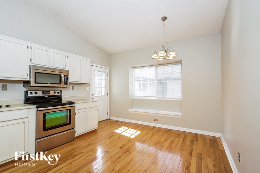 an empty kitchen with white cabinets and stainless steel appliances