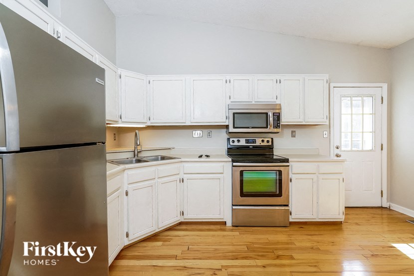 a kitchen with white cabinets and stainless steel appliances