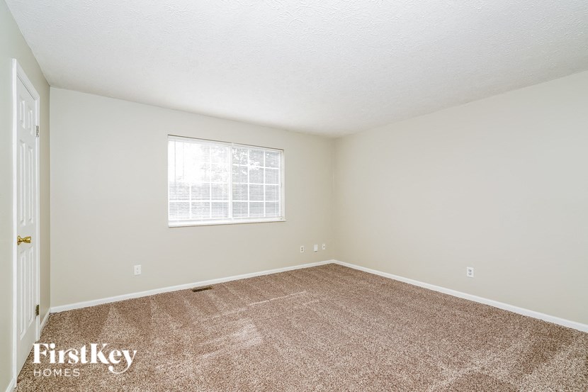 a bedroom with carpet and a window