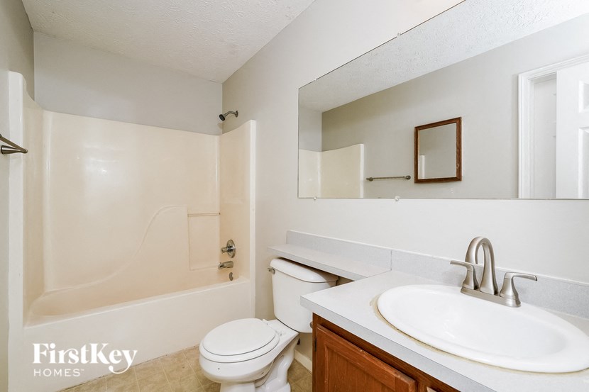 a bathroom with a sink toilet and a mirror