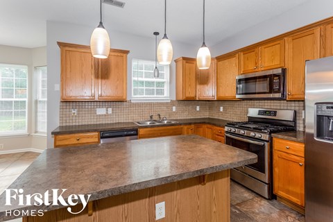 A kitchen with wooden cabinets and a granite countertop.