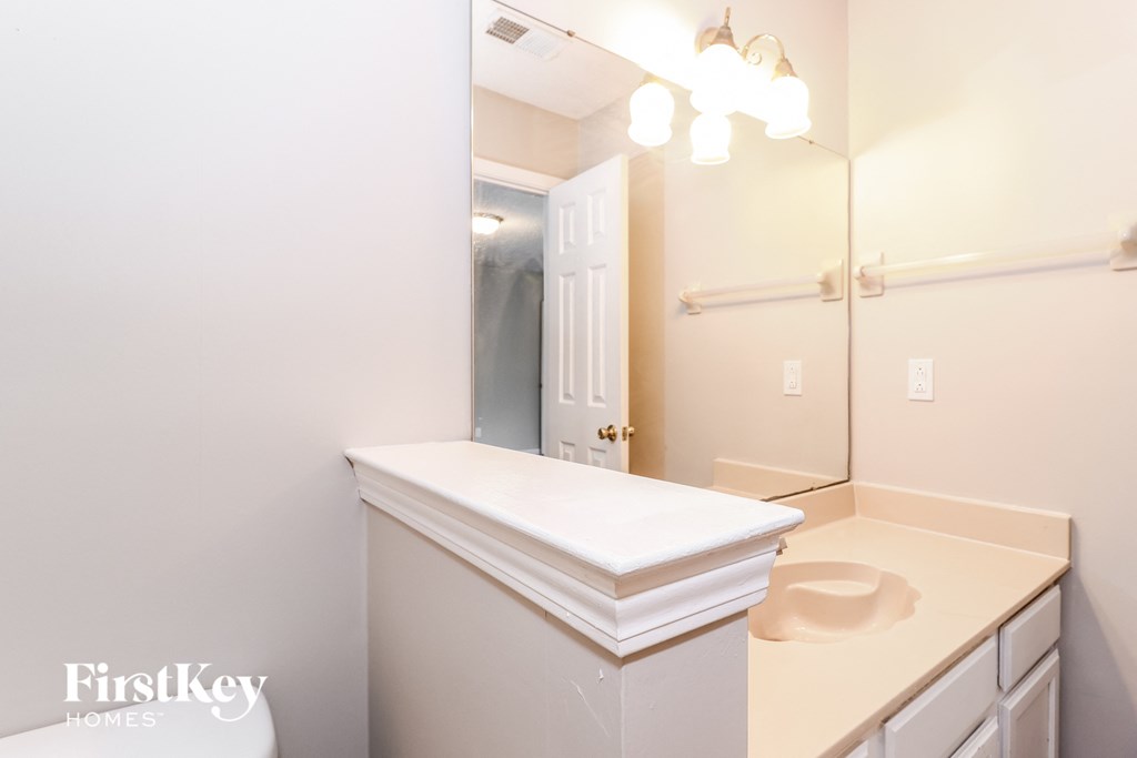 a white bathroom with a sink and a mirror