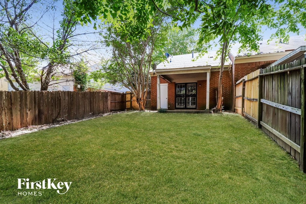 a backyard with a yard and a fence and a house