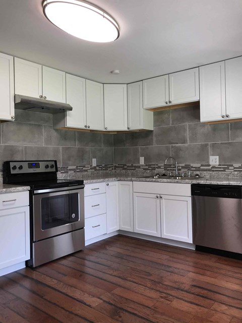 A kitchen with white cabinets and a black oven.