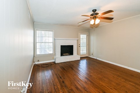 a living room with a ceiling fan and a fireplace