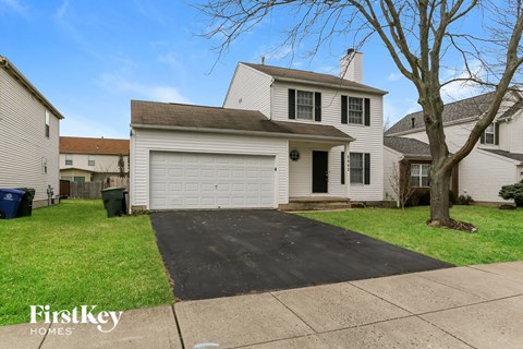 a white house with a white garage door on a driveway