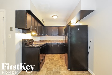 A kitchen with black appliances and cabinets is shown.