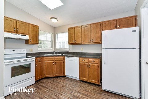 a kitchen with white appliances and wooden cabinets