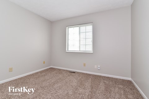 a bedroom with carpet and a window