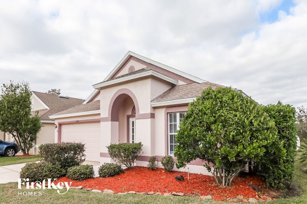 A house with a red mulch bed in front of it.
