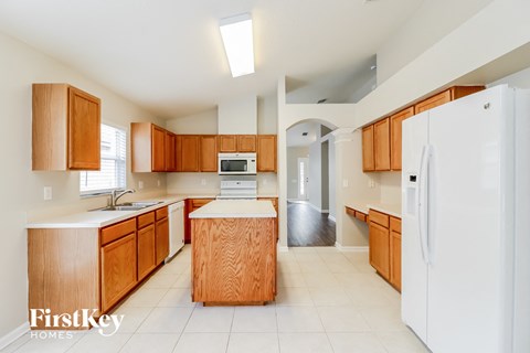 A kitchen with wooden cabinets and a white refrigerator.