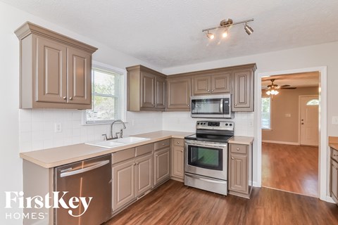 A kitchen with wooden cabinets and a stainless steel dishwasher.
