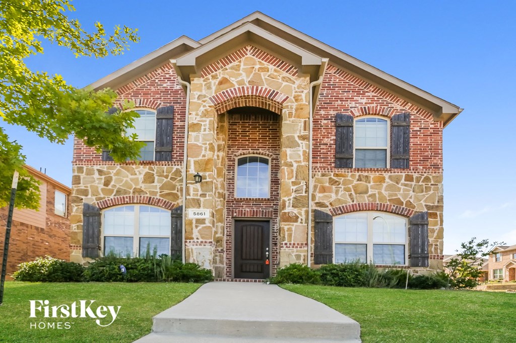 a large brick house with a sidewalk in front of it