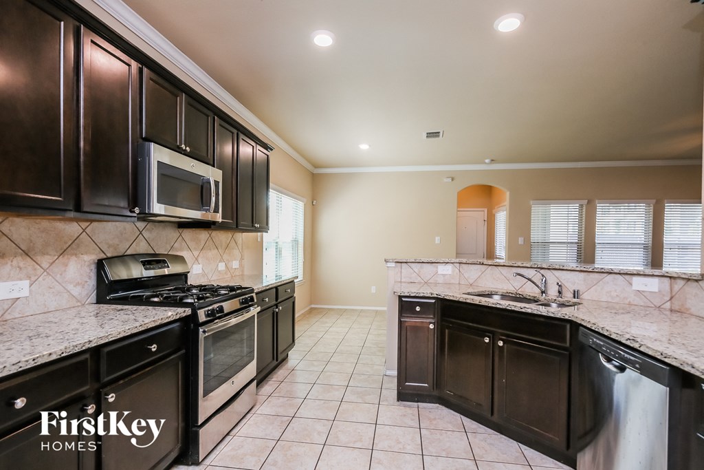 a kitchen with stainless steel appliances and marble counter tops