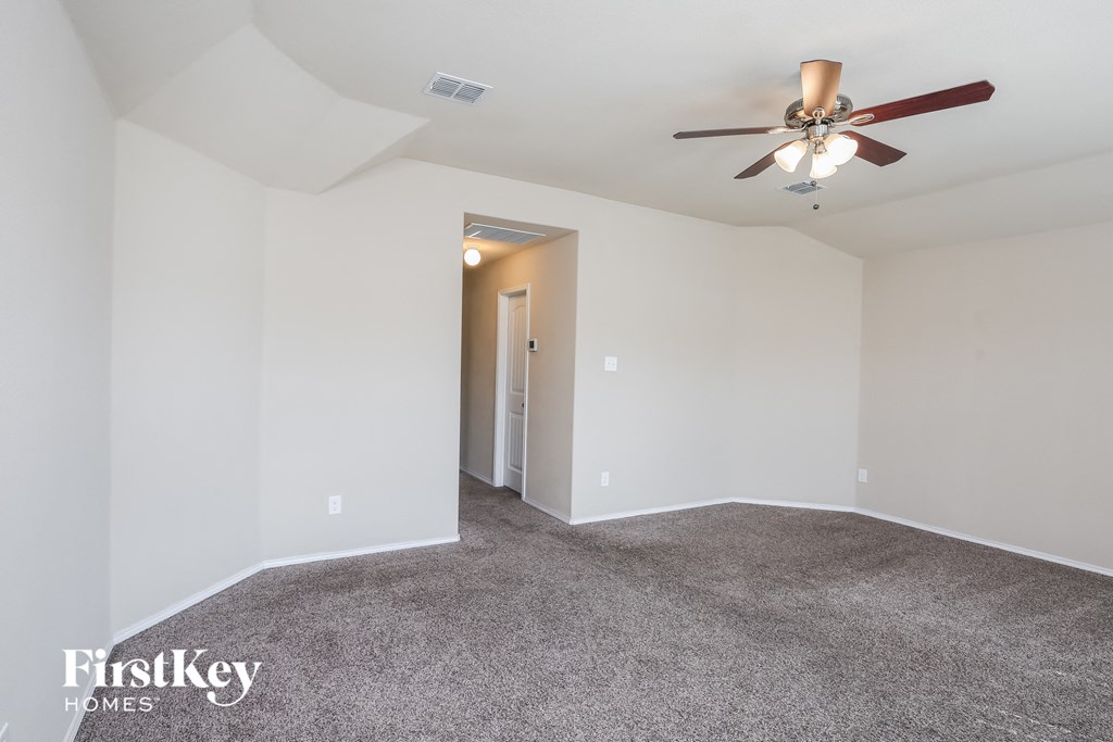 a living room with carpet and a ceiling fan
