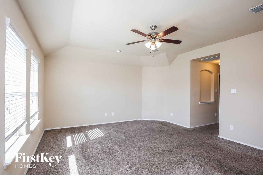 a living room with carpet and a ceiling fan