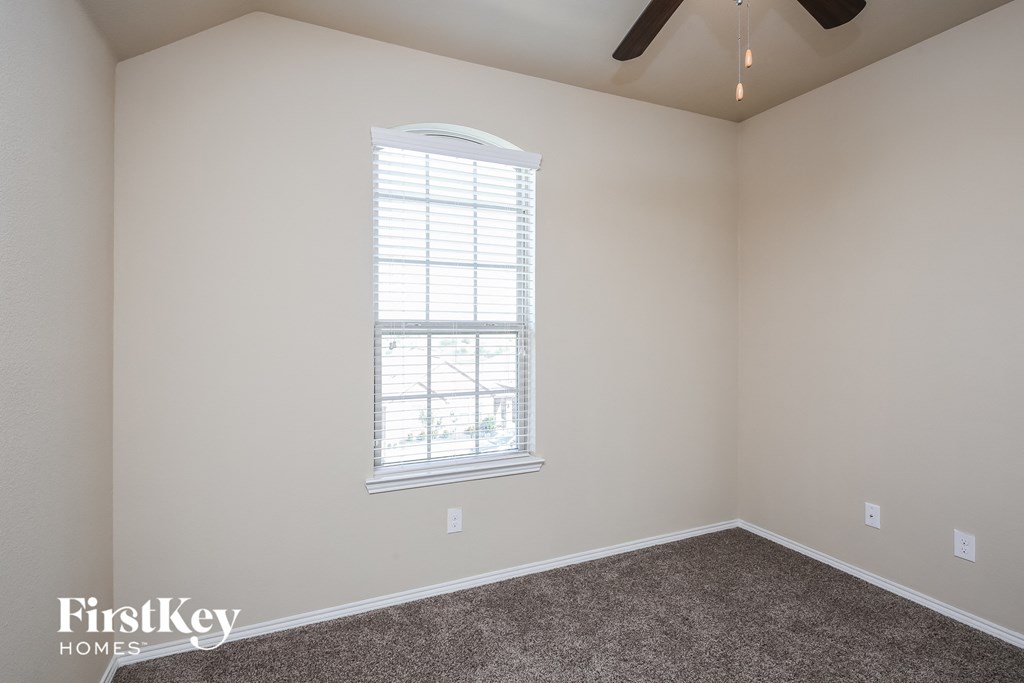 a bedroom with a ceiling fan and a window