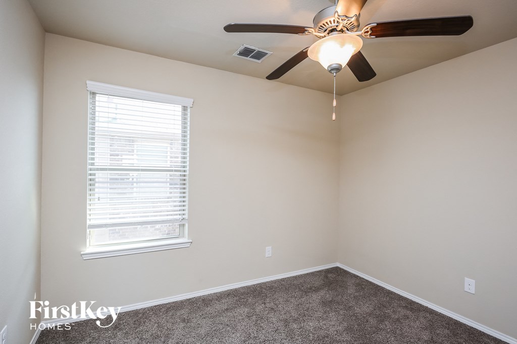 a bedroom with a ceiling fan and a window