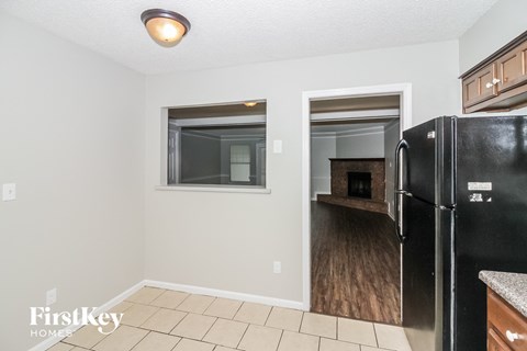 A kitchen with a black fridge and a window.