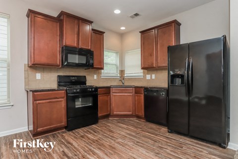 A kitchen with wooden cabinets and black appliances.