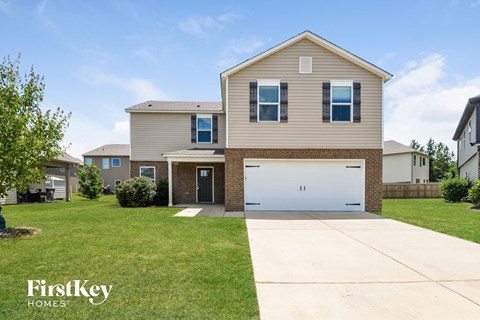 a beige house with a white garage door in front of a lawn
