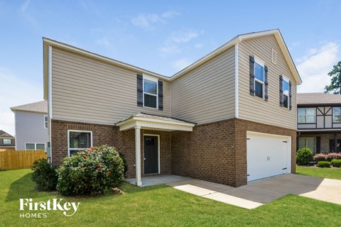 a tan brick house with a white garage door