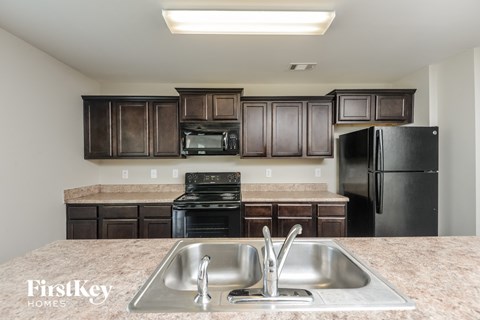 a kitchen with black appliances and granite counter tops