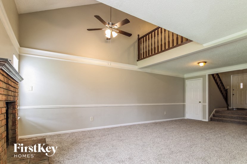 the living room of an empty house with a ceiling fan