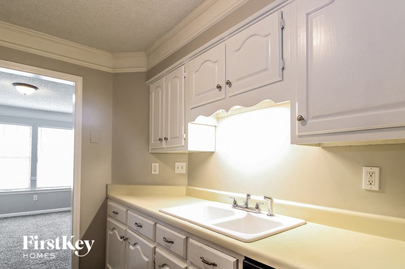a kitchen with white cabinets and a white sink