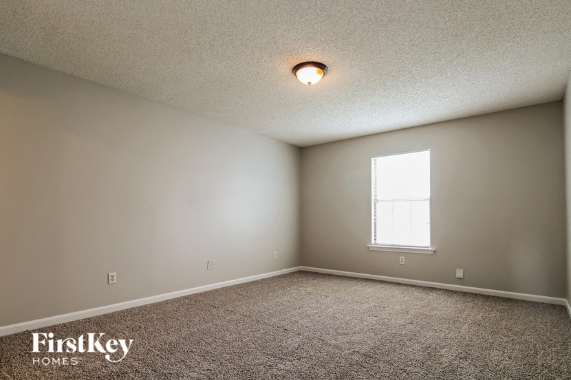 the upstairs bedroom has carpet and a window