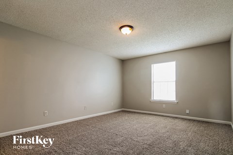 the upstairs bedroom has carpet and a window
