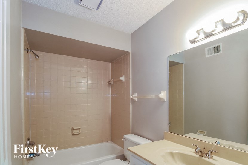 a bathroom with a shower toilet and sink and a mirror